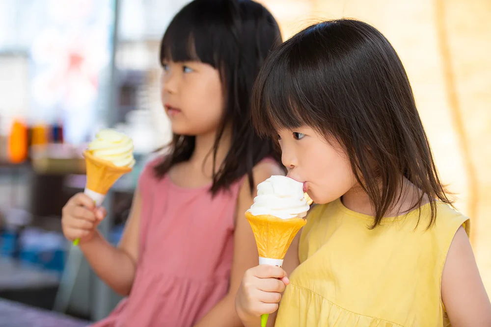 冷たいソフトクリームを食べる子どもたち