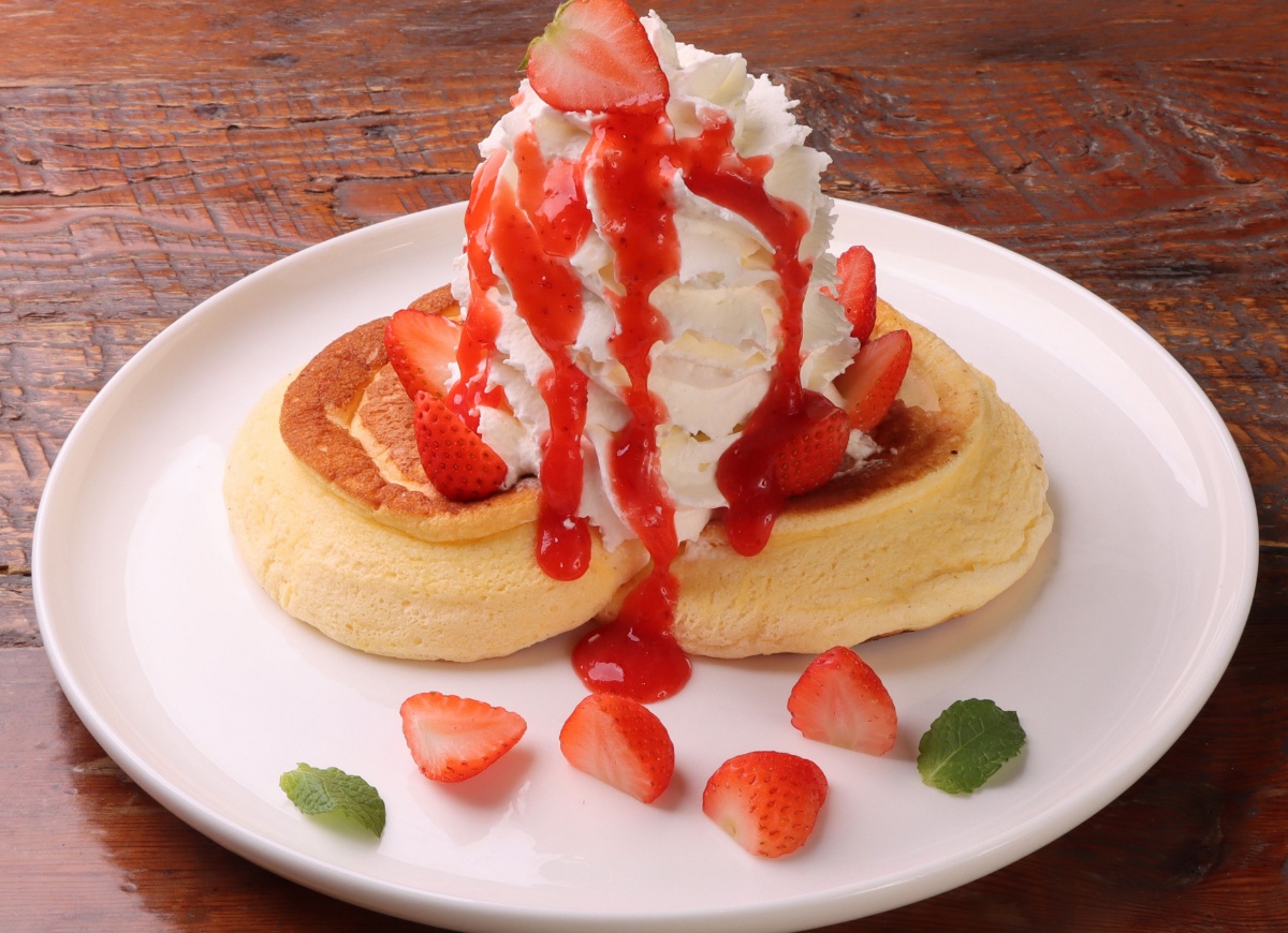 Fluffy whipped cream pancakes with condensed milk and strawberries